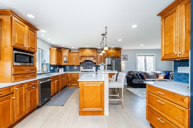 8001 William Dr, Willowbrook, IL 60527 - kitchen with a kitchen breakfast bar, light wood-type flooring, a sink, stainless steel appliances, and brown cabinets