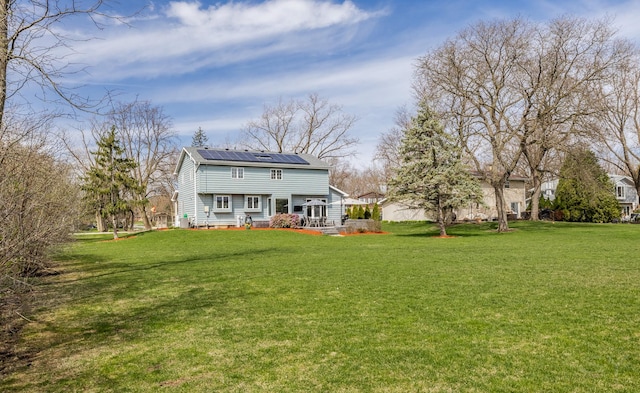 8001 William Dr, Willowbrook, IL 60527 - rear view of property with metal roof, a lawn, and roof mounted solar panels
