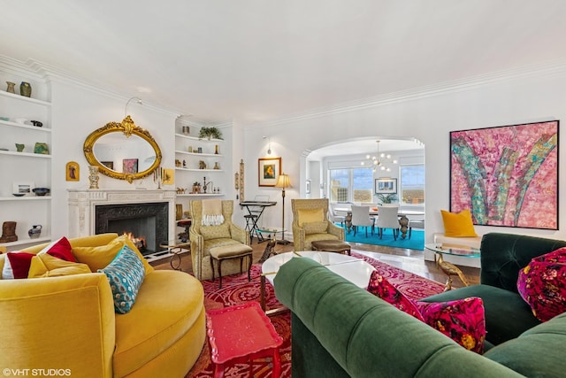 sitting room with baseboards, crown molding, built in features, and a premium fireplace