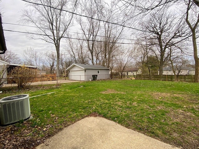 view of yard with central AC, fence, an outbuilding, and a garage