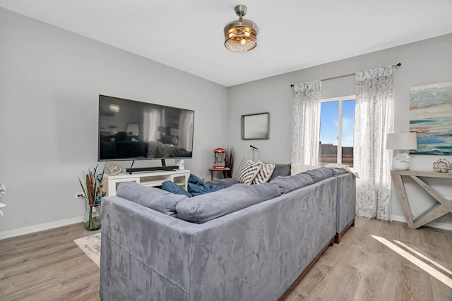 living area with light wood-type flooring and baseboards