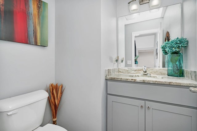 half bathroom with toilet and vanity
