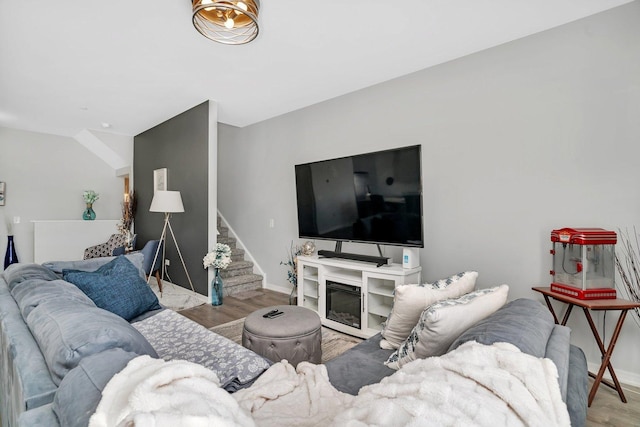 living area featuring stairway, baseboards, and wood finished floors