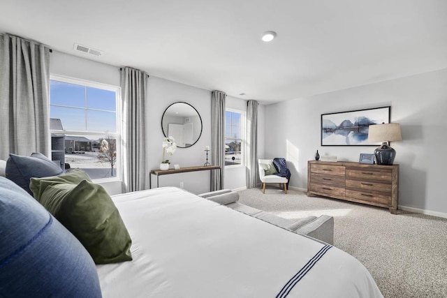 bedroom with baseboards, multiple windows, visible vents, and carpet floors