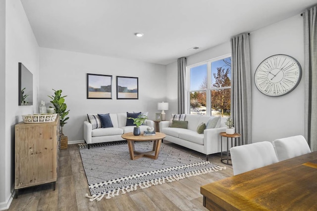 living room featuring wood finished floors, baseboards, visible vents, and recessed lighting