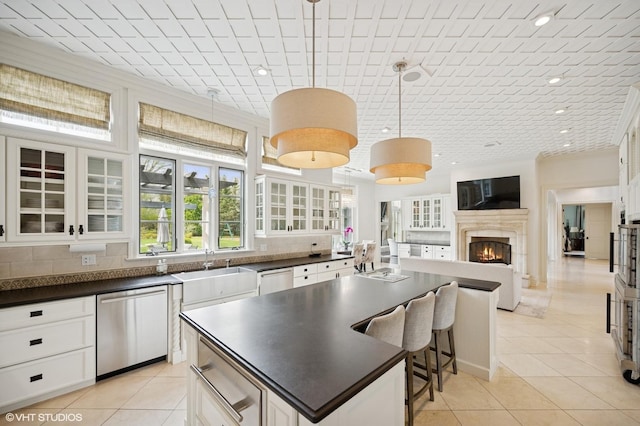 494 Sheridan Rd, Glencoe, IL 60022 - kitchen with light tile patterned flooring, dark countertops, a sink, stainless steel dishwasher, and a kitchen island