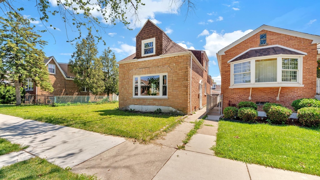 3843 W 56th St, Chicago, IL 60629 - bungalow with a front yard, brick siding, and fence