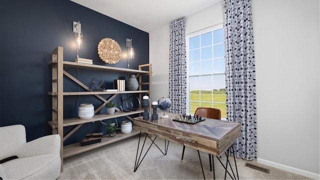 office space with a wealth of natural light, visible vents, baseboards, and carpet floors