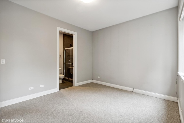 unfurnished bedroom featuring connected bathroom, baseboards, and carpet