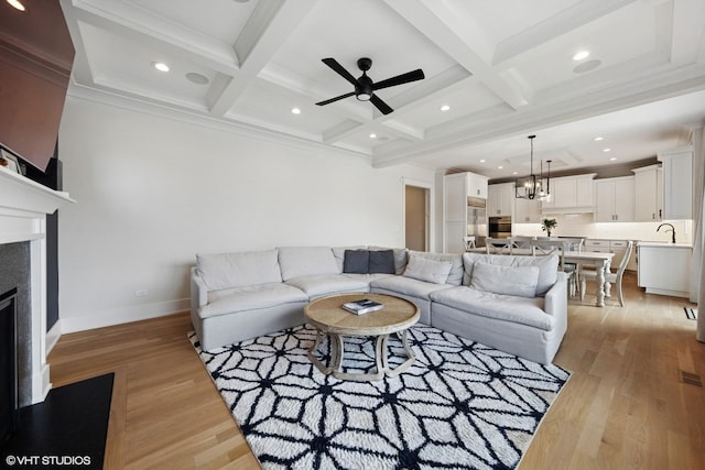 living area featuring baseboards, coffered ceiling, beam ceiling, and light wood-type flooring