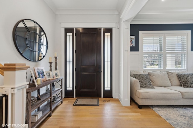 entrance foyer with light wood finished floors and crown molding