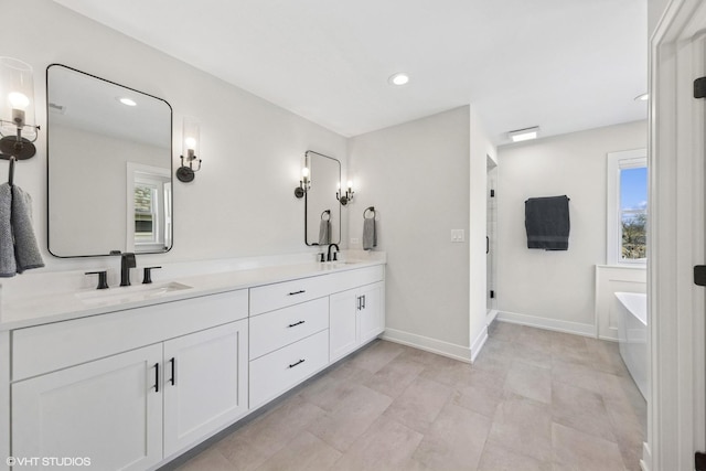 full bath with double vanity, a wealth of natural light, and a sink