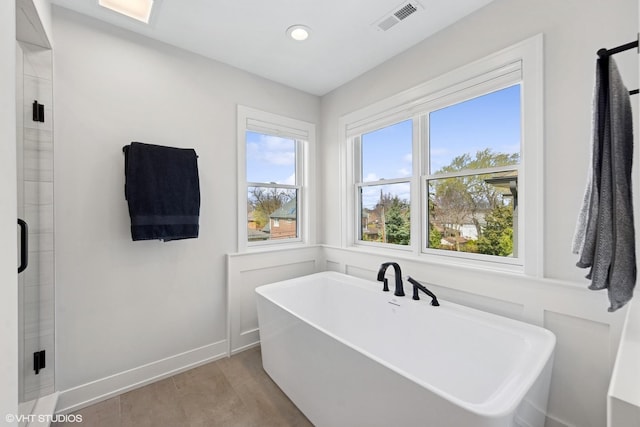 full bath with wood finished floors, a soaking tub, baseboards, visible vents, and recessed lighting