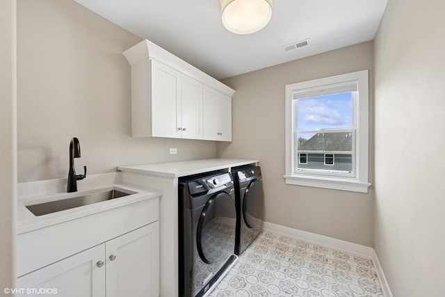 clothes washing area featuring a sink, washer and dryer, cabinet space, baseboards, and visible vents