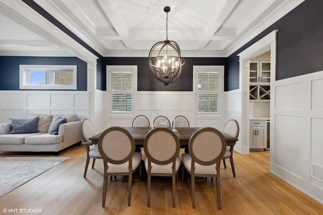 dining space with a chandelier, a wealth of natural light, and coffered ceiling