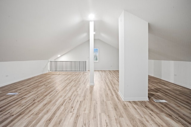 additional living space with visible vents, baseboards, wood finished floors, and lofted ceiling