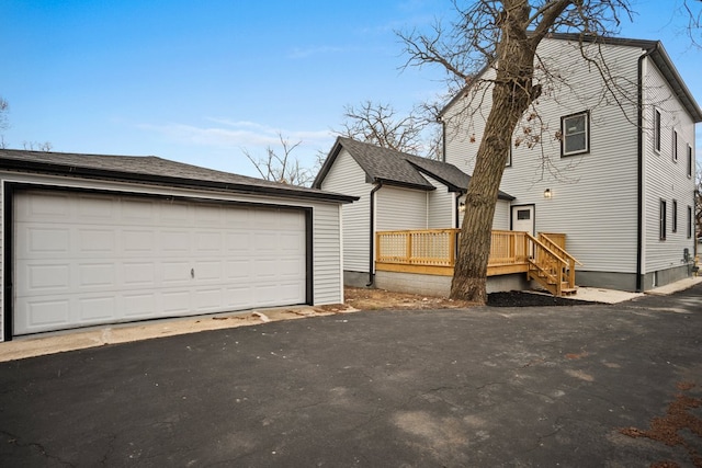 view of front of house with an outbuilding, a wooden deck, and a detached garage