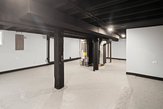 finished basement featuring baseboards, electric panel, and water heater