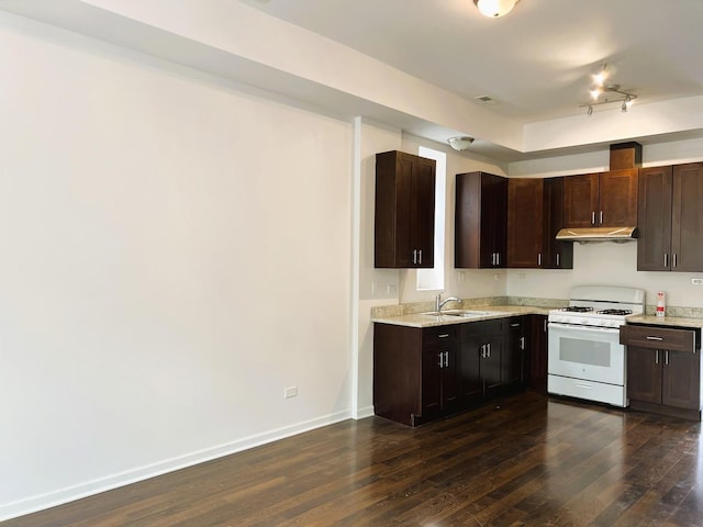 3436 S Wallace St, Chicago, IL 60616 - kitchen featuring under cabinet range hood, dark brown cabinets, rail lighting, dark wood-type flooring, and gas range gas stove