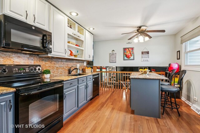 403 E Amherst St, Palatine, IL 60074 - kitchen with a sink, white cabinets, light wood finished floors, and black appliances