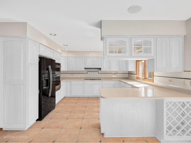 14320 Claridge Ct, Orland Park, IL 60462 - kitchen with tasteful backsplash, a sink, a peninsula, black appliances, and white cabinetry