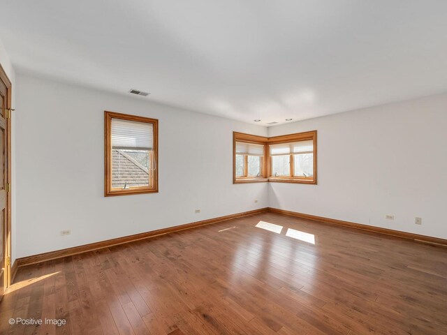 14320 Claridge Ct, Orland Park, IL 60462 - unfurnished room with visible vents, baseboards, wood finished floors, and a healthy amount of sunlight
