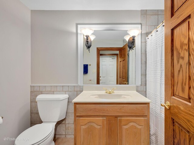 14320 Claridge Ct, Orland Park, IL 60462 - bathroom with toilet, vanity, a wainscoted wall, and tile walls