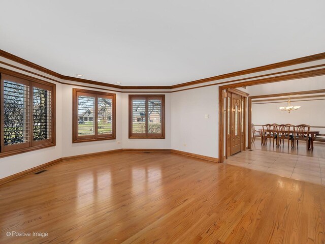 14320 Claridge Ct, Orland Park, IL 60462 - unfurnished living room featuring visible vents, baseboards, a chandelier, crown molding, and light wood-style flooring