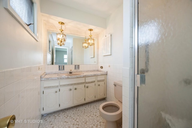bathroom with a shower stall, vanity, toilet, tile walls, and a notable chandelier