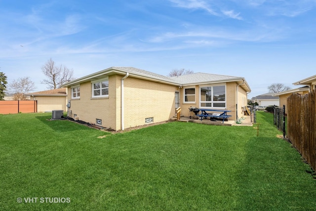 rear view of property with a patio area, brick siding, central AC, a fenced backyard, and a lawn