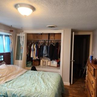 327 W Division, Amboy, IL 61310 - bedroom with dark wood-type flooring, a textured ceiling, a closet, and baseboards