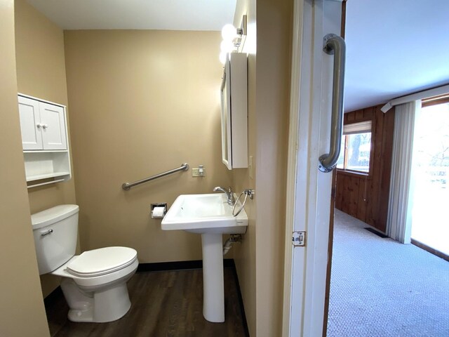 1657 Clay St, Woodstock, IL 60098 - half bath with toilet, baseboards, wood finished floors, and a sink