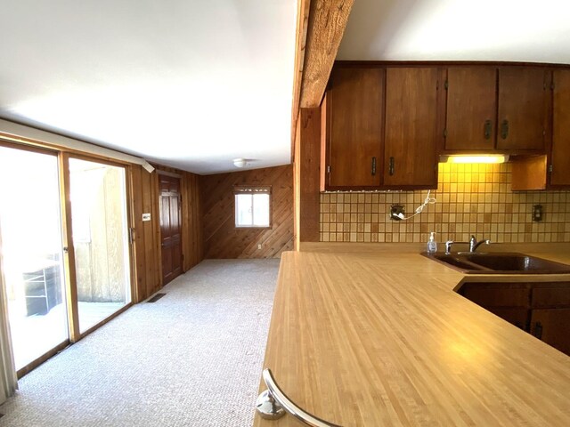 1657 Clay St, Woodstock, IL 60098 - kitchen with a sink, light countertops, tasteful backsplash, wooden walls, and light colored carpet