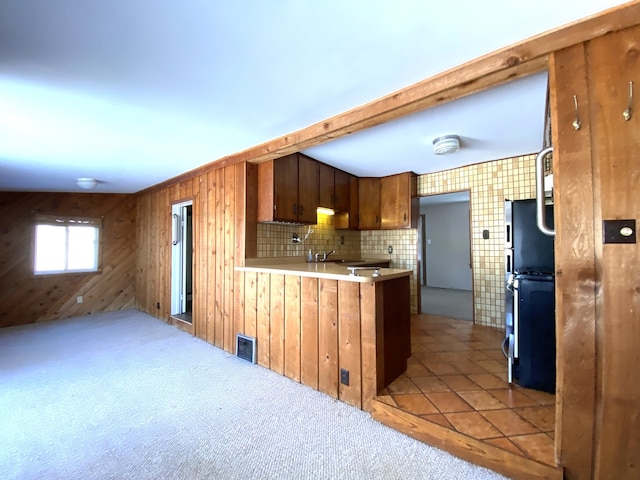 1657 Clay St, Woodstock, IL 60098 - kitchen with a peninsula, light countertops, wooden walls, carpet flooring, and a sink