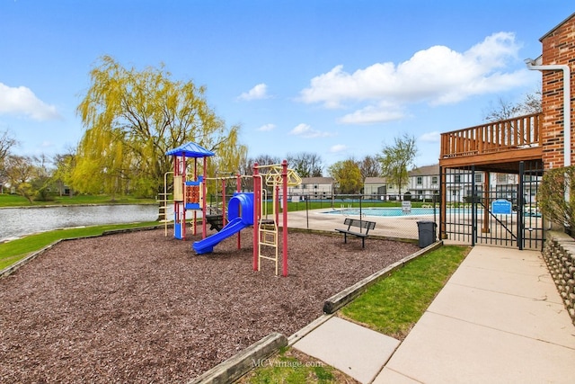 community jungle gym featuring a community pool, a water view, and fence