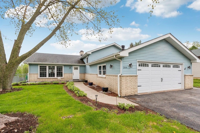 split level home featuring brick siding, a chimney, asphalt driveway, and a garage