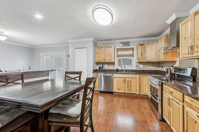 kitchen featuring appliances with stainless steel finishes, a sink, light brown cabinetry, dark wood-style floors, and crown molding