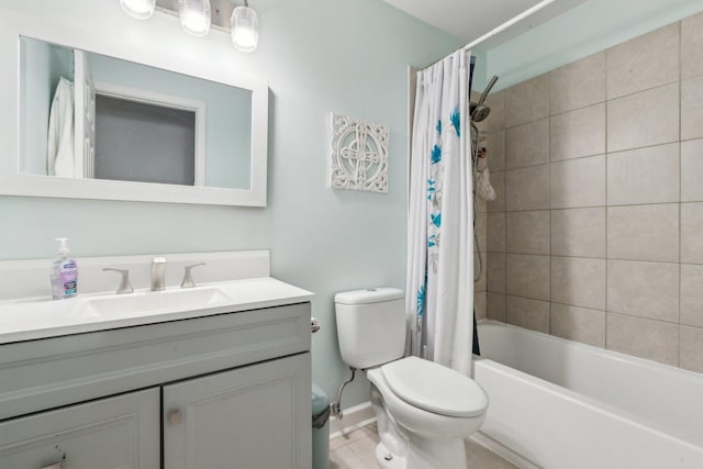 bathroom featuring tile patterned flooring, toilet, vanity, shower / bath combo, and baseboards