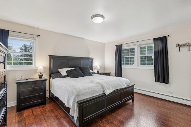 bedroom with dark wood finished floors and a baseboard heating unit
