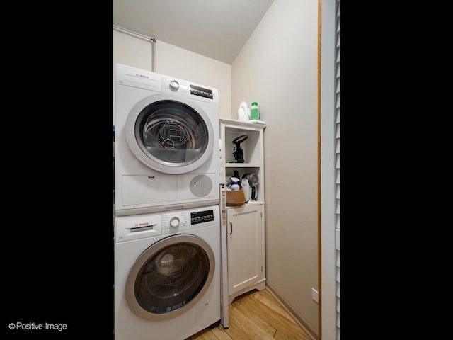 3323 N Paulina St Unit 5F, Chicago, IL 60657 - laundry room with stacked washing machine and dryer, cabinet space, and light wood-style floors
