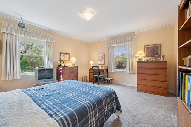 carpeted bedroom featuring crown molding, baseboards, and multiple windows