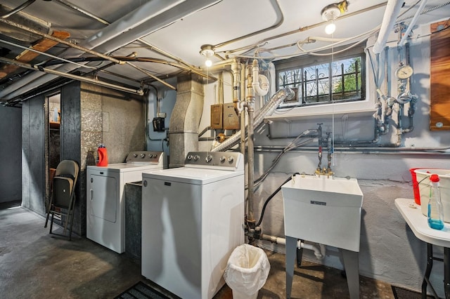 laundry area with laundry area, a sink, and washer and clothes dryer