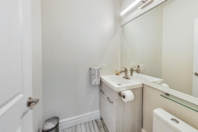 half bathroom featuring vanity and toilet