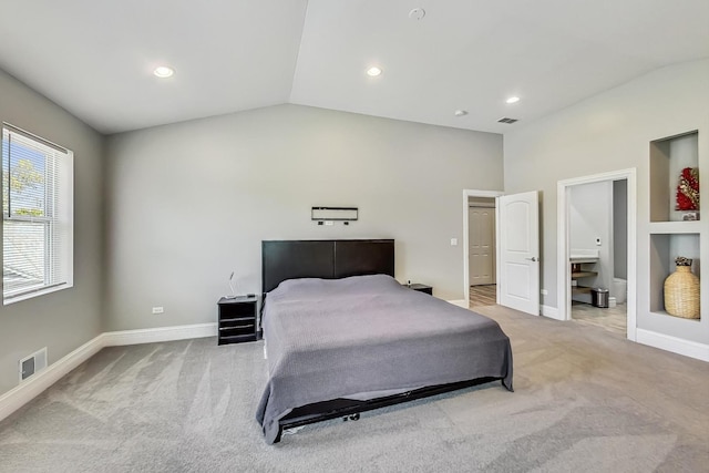 bedroom with visible vents, light colored carpet, and vaulted ceiling
