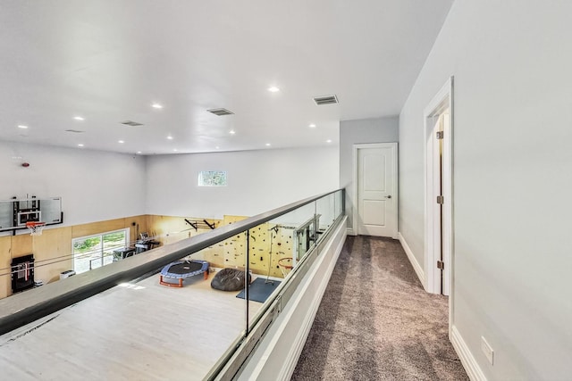 hall featuring a wealth of natural light, carpet, and visible vents