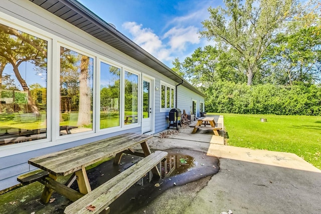 view of side of home featuring a patio and a lawn