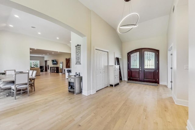 foyer entrance featuring visible vents, arched walkways, light wood finished floors, recessed lighting, and high vaulted ceiling