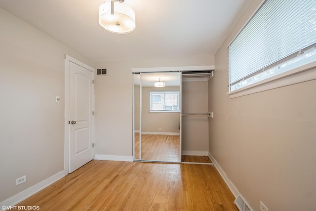 8518 S Avalon Ave, Chicago, IL 60619 - unfurnished bedroom with light wood-style floors, a closet, and baseboards