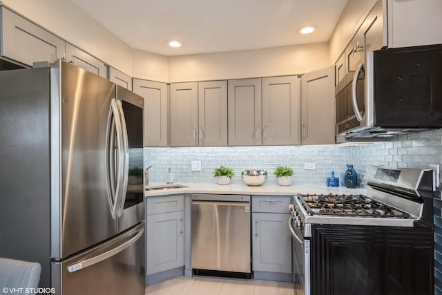8518 S Avalon Ave, Chicago, IL 60619 - kitchen with appliances with stainless steel finishes, gray cabinets, a sink, light countertops, and tasteful backsplash
