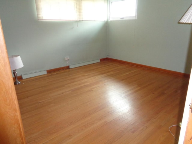 4603 Rose St, Schiller Park, IL 60176 - spare room featuring visible vents, baseboards, baseboard heating, wood finished floors, and a baseboard heating unit